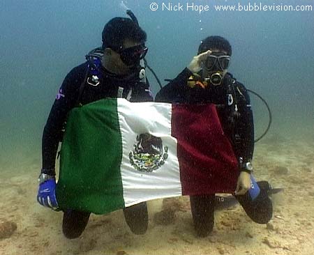Scuba divers holding Mexico flag